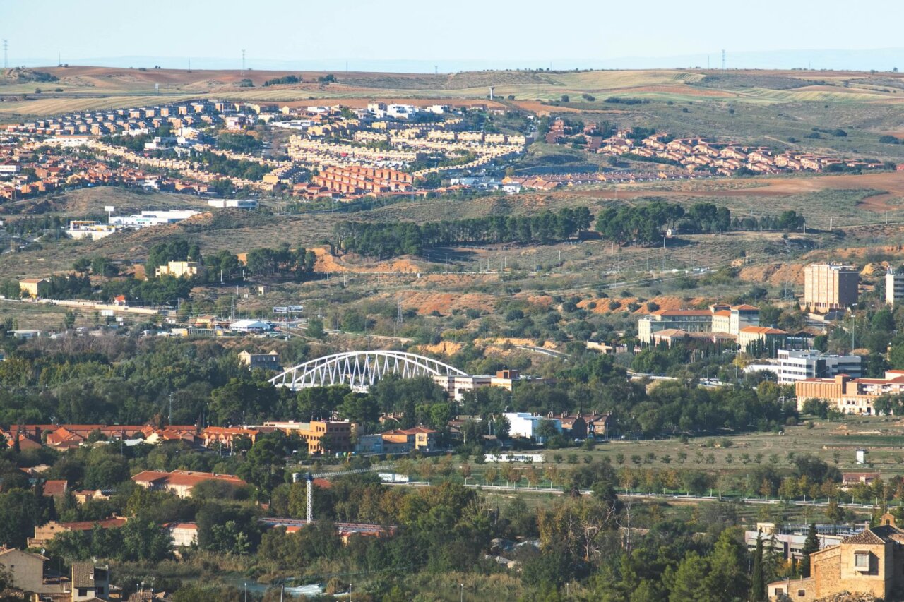 Construction workers are seen laying foundations for new training pitches at the Real Madrid sports complex in Valdebebas, while nearby residents express concerns about the impact on their community.