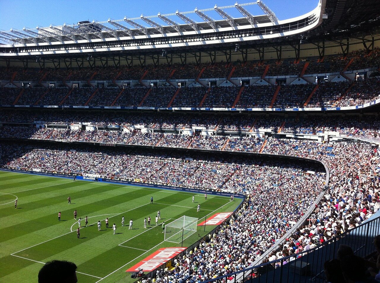Bernardo Silva is seen signing his contract with Real Madrid officials in a press conference, marking his transition from Manchester City to the Spanish club.
